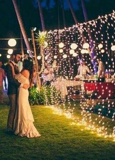 a bride and groom are standing in the grass with their arms around each other as they dance