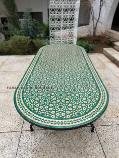 a green and white table sitting on top of a tiled floor