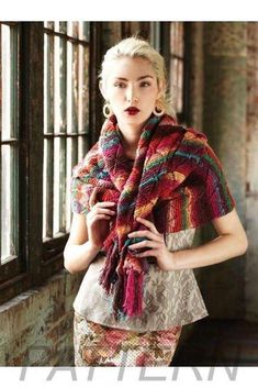 a woman is standing in front of a window wearing a scarf