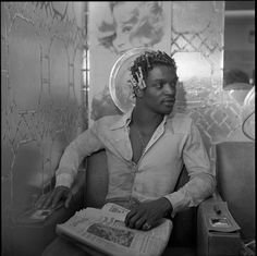 a man sitting in a chair reading a newspaper