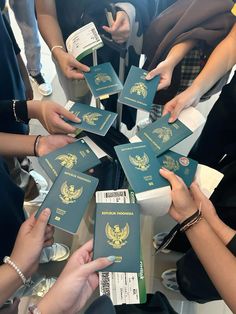 many people are holding their passport in the middle of a table