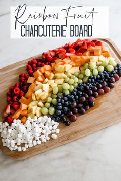 a wooden cutting board topped with fruit and veggies