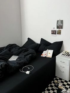 a bedroom with black and white checkered flooring is pictured in this image, there are two nightstands on either side of the bed