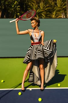 a woman holding a tennis racquet standing on top of a tennis ball court