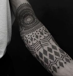 a man's arm with an intricate tattoo design on the left forearm and wrist