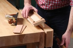 a man is working with woodworking tools on a workbench