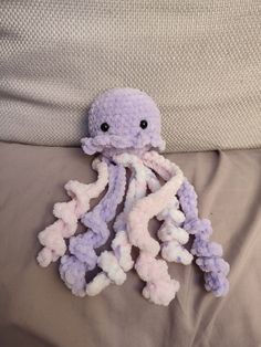 an octopus stuffed animal sitting on top of a bed