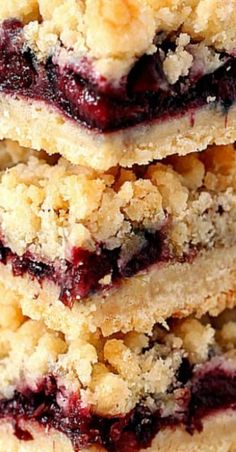 a stack of blueberry crumb bars on top of each other with a cherry on top