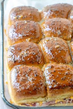 a baking dish filled with rolls covered in cheese