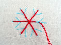 a close up of a piece of cloth with red and blue thread