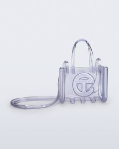 The small Melissa x Telfar Jelly Shopper — features a fluid design and tubular construction. This transparent shopper is water-resistant and concert + festival compliant, making it an instant summer staple. Molded using Melissa's exclusive Melflex materials, it looks extra bomb with the matching slides. Small is the party-bag + the afterparty too. The Afterparty, Jelly Bag, Handbag Essentials, Fluid Design, Fasion Outfits, Concert Festival, Girly Bags, Marc Jacobs Bag, Cute Purses