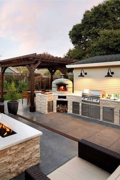 an outdoor kitchen with grill and seating area