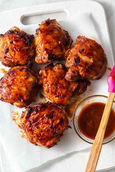 chicken wings with sauce on the side and a pink spatula next to it, ready to be eaten