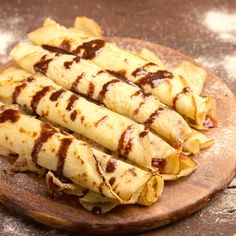 some tortillas on a wooden plate with sauce drizzled over them