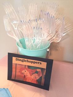 there are plastic utensils in a bucket on the table with a sign that says dinggieshoppers