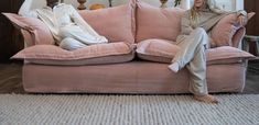 two people are sitting on a pink couch