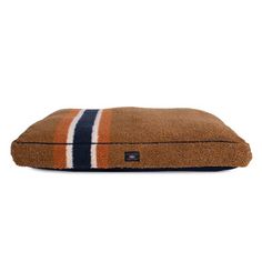 a brown dog bed with blue, white and orange stripes