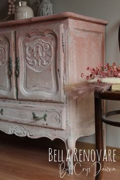 an old dresser is painted pink and has flowers on top