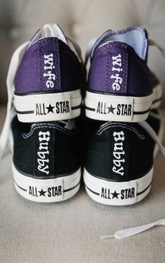 two black and purple converse shoes with all star logos on the bottom, one has white laces