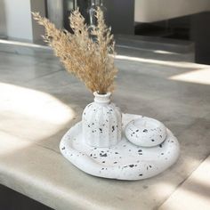 a white vase sitting on top of a counter