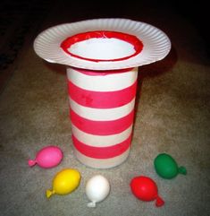 a paper cup filled with candy on top of a floor next to other candies