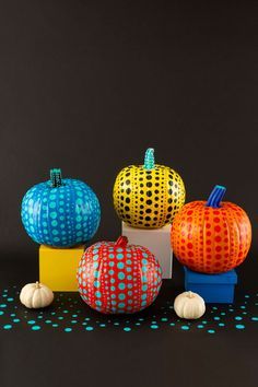 colorful pumpkins sitting on top of each other in front of a black background with polka dots