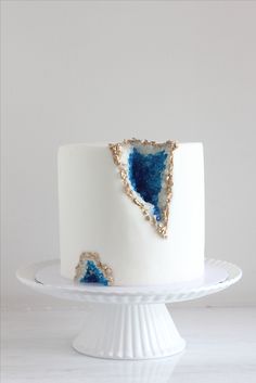 a white cake with blue and gold decorations