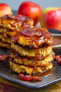 stack of pancakes with syrup and apples in the background