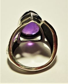 "Amethyst ring with a large pear shaped purple amethyst cabochon gemstone, set in a sterling silver leaf design ring, in a size 6 This vintage ring features a large royal purple amethyst pear amethyst cabochon, set in a solid sterling ring, with a beautiful large leaf embellishment on each side. The ring is a size 6. The polished bezel setting shows off the large, clear and very high quality genuine 16mm x 12mm amethyst jewel. It is stamped \"925\" for solid sterling inside the band. The ring ha Amethyst Gem, Purple Band, Vintage Purple, Royal Purple, Custom Jewelry Design, Vintage Ring, Amethyst Ring, Silver Leaf, Jewelry Gift Box