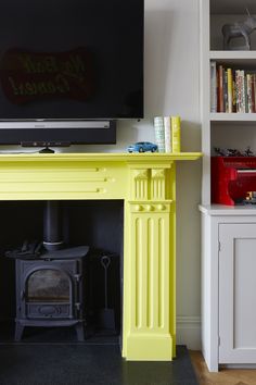 there is a television on the stand in front of the fire place and bookshelves