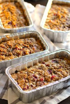 four metal pans filled with baked goods on top of a table