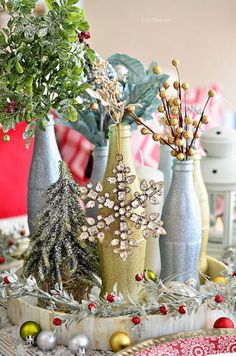 three vases filled with christmas decorations on top of a table