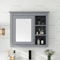 a bathroom sink with a medicine cabinet above it and a mirror on the wall next to it