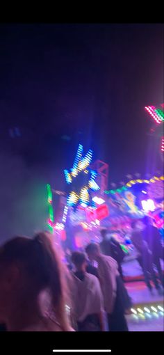 people standing in front of a carnival ride at night