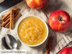 apples and cinnamon sticks are next to a bowl of oatmeal