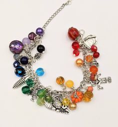 "- Autumn Charm Bracelet Stainless Steel Chain is adjustable from 6.5\" - 9\" with a lobster claw closure and extension chain The bracelet links are filled with a rainbow of glass and gem stone beads and crystals - really pretty. Mixed between the beads and gemstones are autumn themed silver and enamel charms. This is a great gift for anyone who loves the quirky symbols and bright colors of fall. I make these as they are ordered, so the processing time is 4 days. Your bracelet will be carefully Multicolor Dangle Jewelry With Lobster Clasp, Rainbow Metal Jewelry For Jewelry Making, Nickel-free Multicolor Metal Charm Bracelet, Multicolor Beaded Metal Charm Bracelet, Rainbow Metal Jewelry With Adjustable Chain, Metal Beaded Dangle Charm Bracelet, Adjustable Rainbow Jewelry With Lobster Clasp, Multicolor Dangle Charm Bracelet, Nickel-free Multicolor Charm Bracelet For Jewelry Making