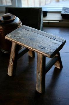 a small wooden stool sitting on top of a hard wood floor