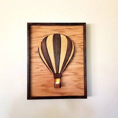 a wooden hot air balloon mounted on a wall with a light bulb in the middle