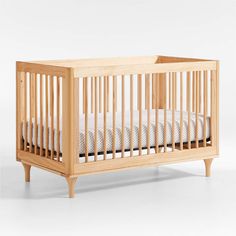 a small wooden crib with white sheets on the bottom and sides, against a white background