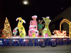 an outdoor display with christmas lights and decorations on it's sides, including three giraffes