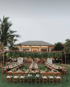 an outdoor dining area with tables and chairs set up for a formal dinner in the grass