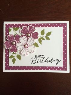 a happy birthday card with flowers and polka dots on the bottom, sitting on a table