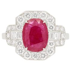 An entrancing red ruby, weighing 1.50 carat, takes centre stage in this marvellous vintage cluster ring. It has been mounted in the ring with four talon claws. The grand halo surrounding is composed with a combination of brilliant cut diamonds and baguette cut diamonds. The round brilliants combine to 0.84 carats and the baguettes total to 0.16 carats. They are all of excellent quality, being F in colour and VS in clarity. The cluster ring has been entirely made of 18ct white gold with cut out patterns, pleasingly decorating the gallery. Gemstone: Ruby Stone Shape: Oval Carat Weight: 1.50 Metal: 18ct White Gold Age: 1960s Size: N Classic Cluster Ruby Ring, Classic Red Cluster Diamond Ring, Vintage Red Diamond Ring With Halo Setting, Classic Red Cluster Ruby Ring, Vintage Gia Certified Ruby Ring For Formal Occasions, Classic Cluster Ruby Ring With Center Stone, Classic Red Ruby Cluster Ring, Classic Ruby Cluster Ring With Center Stone, Cluster Ruby Ring With Center Stone