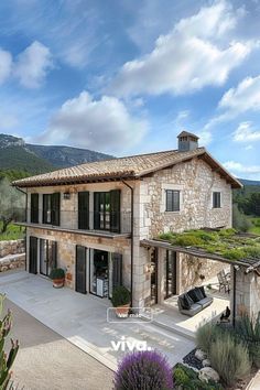 the house is surrounded by greenery and stone