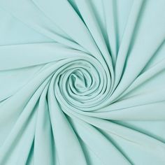 a close up view of a light blue fabric that has been folded in the shape of a spiral