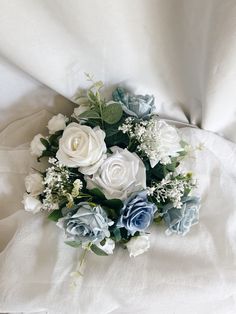 a bouquet of white and blue flowers on a bed