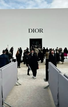 a group of people standing in front of a dior store entrance with the doors open