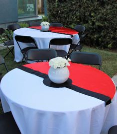 tables with white and red tablecloths are set up outside