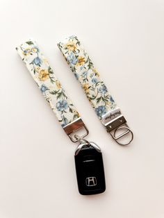 two flowered lanyards with one keychain and the other has a black tag attached to it