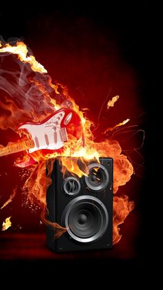 a speaker on fire with a guitar in the back ground and flames behind it,